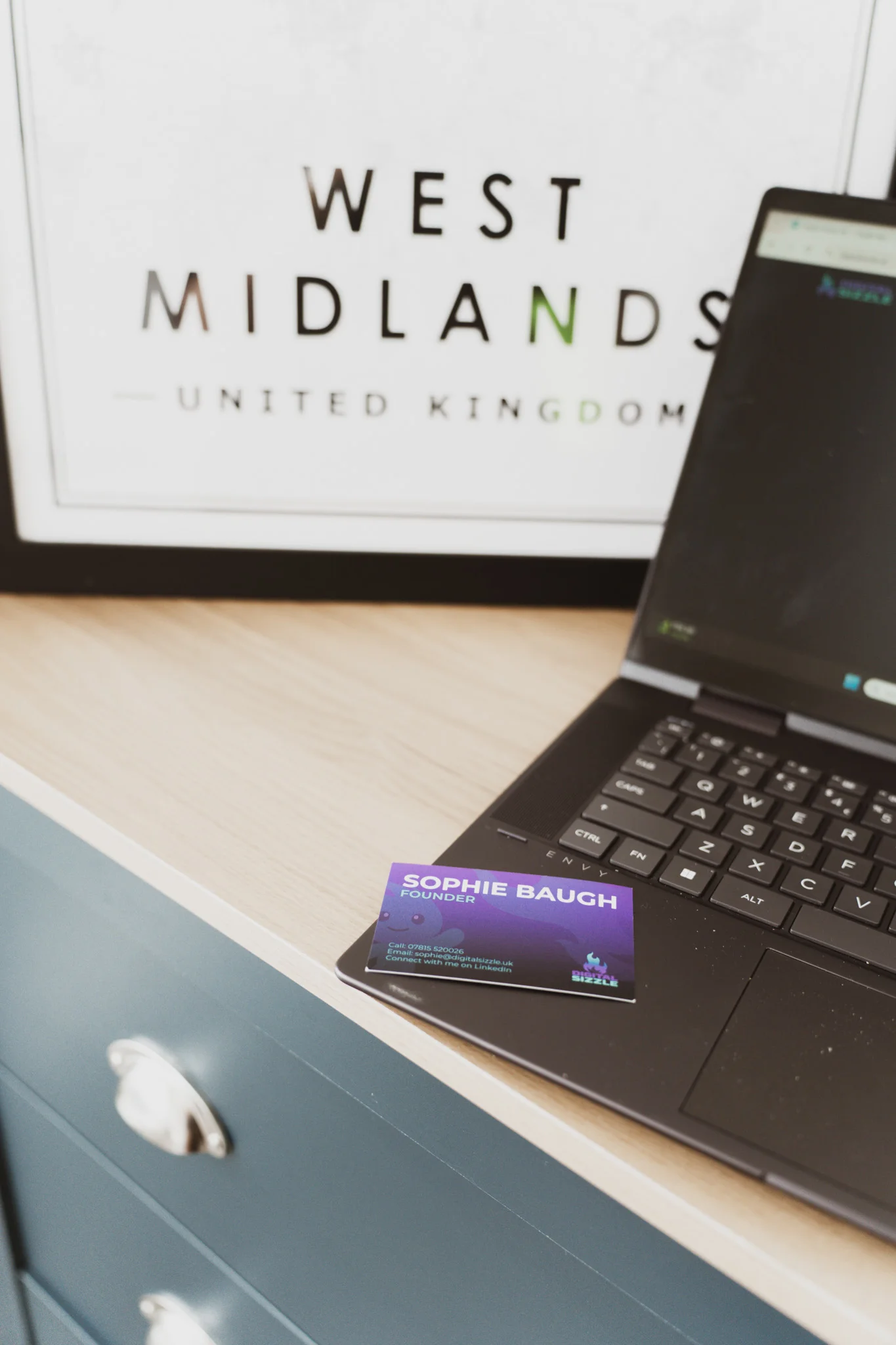 Laptop displaying a client website alongside professionally designed business cards